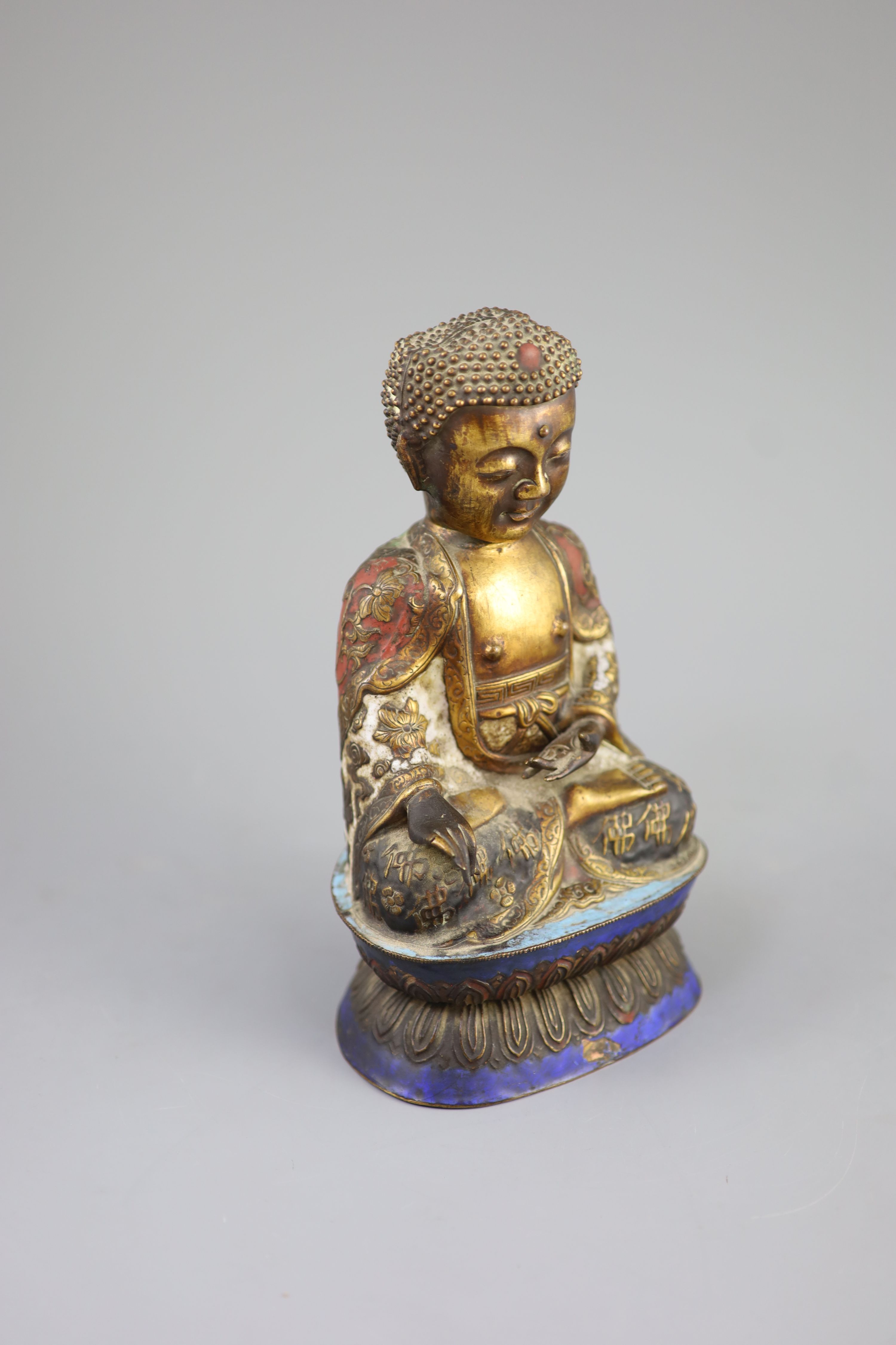A Chinese copper alloy and enamel seated figure of Buddha Shakyamuni, Qing dynasty, 24cm high, faults